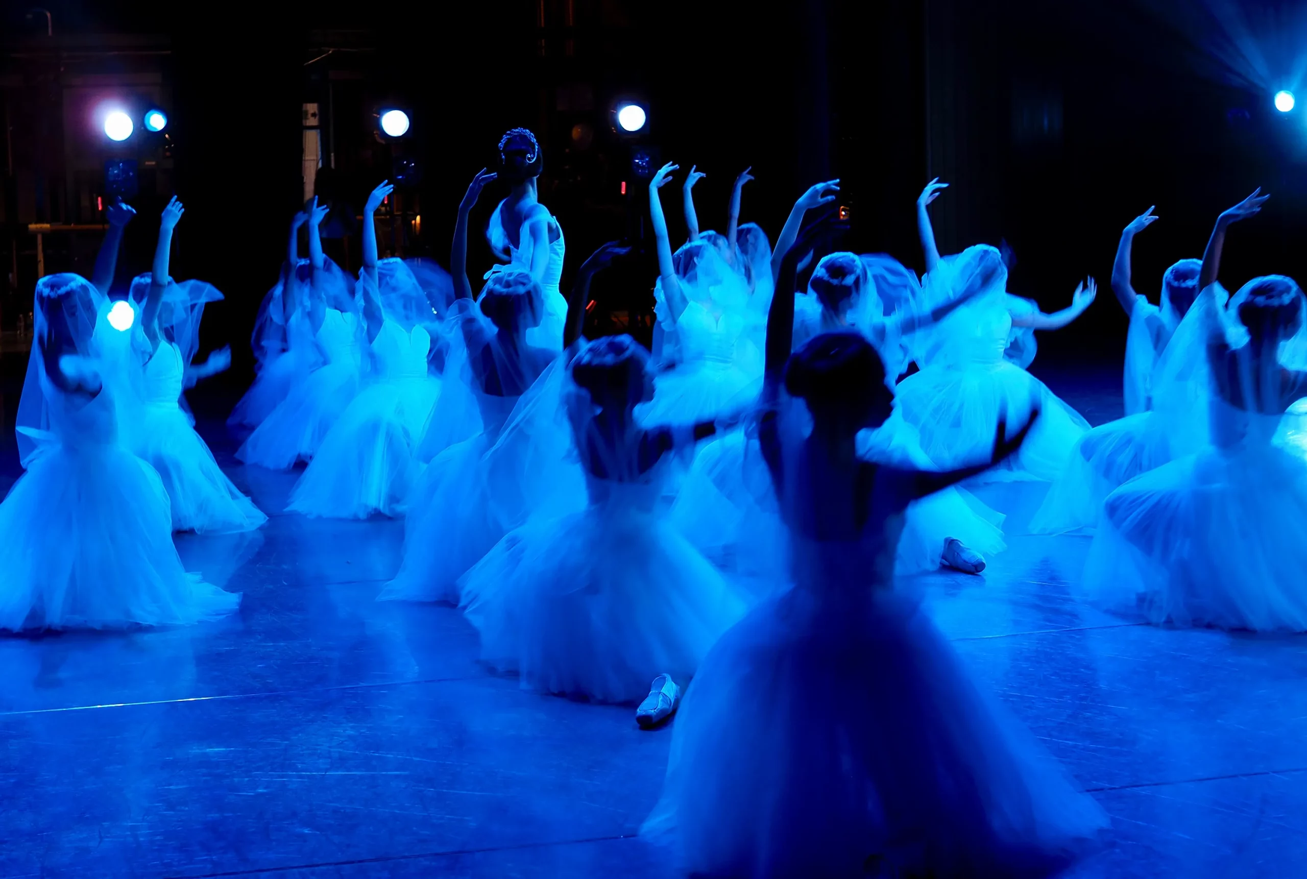 Dancers performing under stage lights.